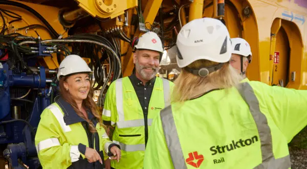 Fyra personer från Strukton Rail som är glada i ett spårområde.